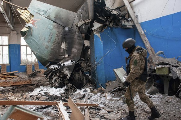 A Ukrainian serviceman walks past the vertical tail fin of a Russian Su-34 bomber lying in a damaged building in Kharkiv, Ukraine.