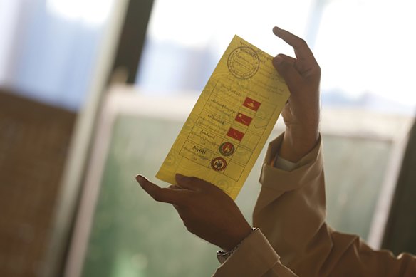 An official of the Union Election Commission displays a rejected ballot at a polling station in Mandalay, Myanmar.
