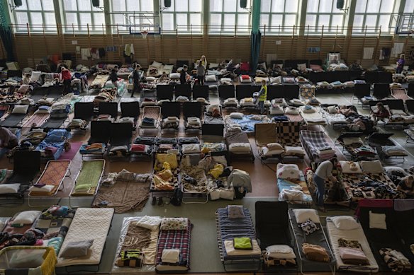 People who fled the war in Ukraine rest inside an indoor sports stadium being used as a refugee center, in the village of Medyka, a border crossing between Poland and Ukraine.