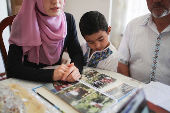 Bilal Oguz, 5, views photos of relatives who have gone missing or are in internment camps.