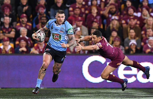 Josh Dugan of the NSW Blues gets past Maroons player Billy Slater to score.