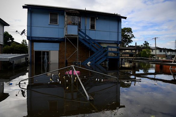 Church street resident Rachel Holland peers down over her back verandah at her submerged clothesline.