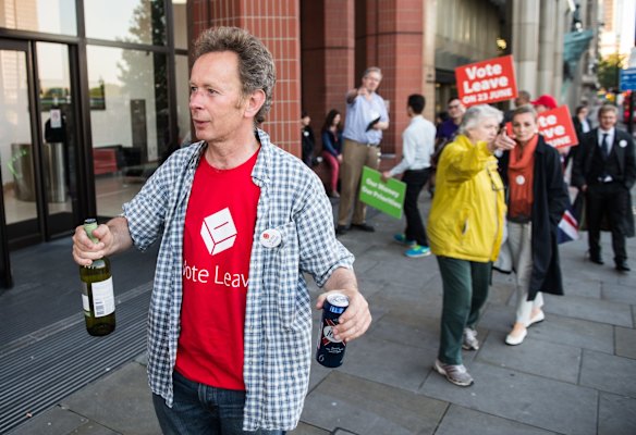 A vote LEAVE supporter with a bottle of wine and can of beer walks outside Vote Leave HQ, Westminster Tower, London.