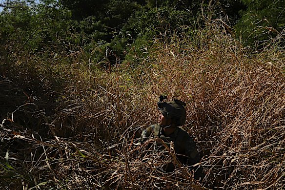 A marine special forces captain who fought in the Battle of Marawi, sits in the grasses near a beach at the Philippine Marine Corp Barracks.