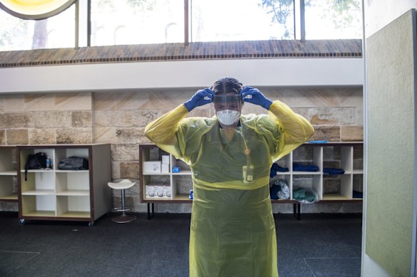 Nurse Rachael Macfarlane adjusts her face shield.