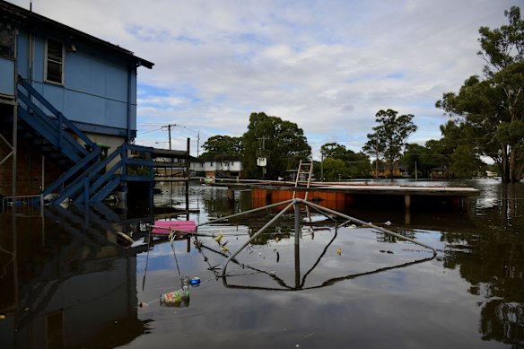 Church street resident Rachel Holland peers down over her back verandah at her submerged clothesline. Until the water recedes later today there is no chance of a clean up.