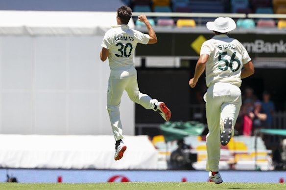 Australia's Pat Cummins, left, celebrates after taking the wicket of England's Ben Stokes during day four of the first Ashes cricket test at the Gabba in Brisbane, Australia, Saturday, Dec. 11, 2021. 