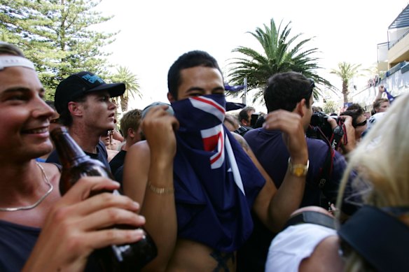 A man hides his face with the Australian flag on the day of violence in Cronulla.