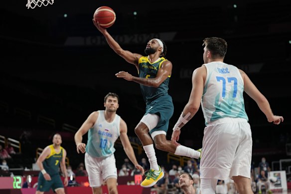 Australia's Patty Mills (5) puts up a shot against Slovenia's Luka Doncic (77) and Mike Tobey (10) during the men's bronze medal basketball game at the 2020 Summer Olympics, Saturday, Aug. 7, 2021, in Tokyo, Japan.