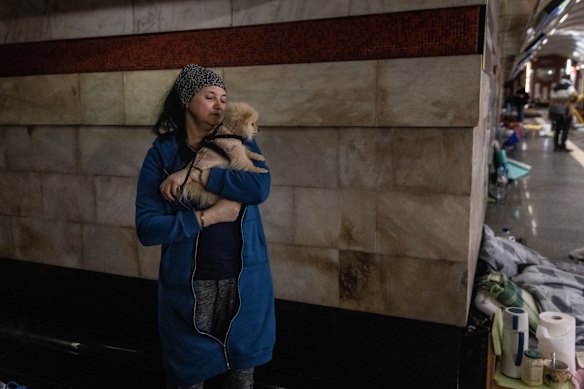 A woman cuddles her dog while sheltering in a metro station that has turned into a bomb shelter in Kyiv. Russian forces remain on the outskirts of the Ukrainian capital, but their advance has stalled in recent days.