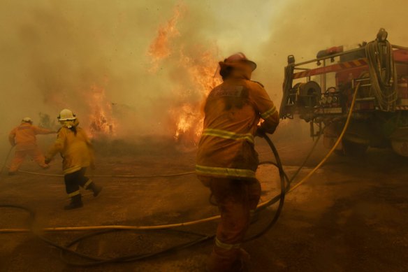 Spot fires threaten to overwhelm RFS volunteer firefighters at the Hillville fire on NSW Mid north coast. Constant swirling winds and dry fuel has allowed the fire to spot often threatening and destroying homes.