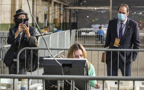 Election observers watch Jessica Lehman as she processes ballots as part of the Allegheny County Return Board's counting of the remaining absentee and mail-in ballots in Pittsburgh. 