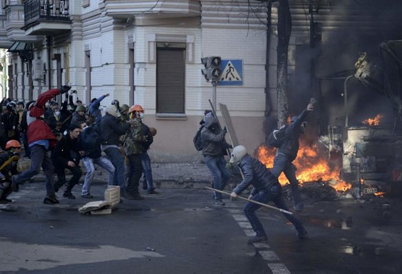 Anti-government protester throw stones towards Interior Ministry members during clashes in Kiev, February 18, 2014. Several thousand anti-government protesters clashed with police near Ukraine's parliament on Tuesday, torching vehicles and hurling stones in the worst violence to rock the capital Kiev in more than three weeks.