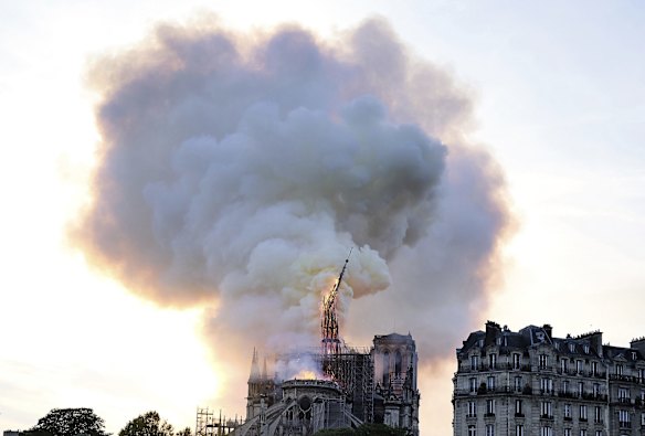Flames and smoke rise as the spire on Notre Dame cathedral.