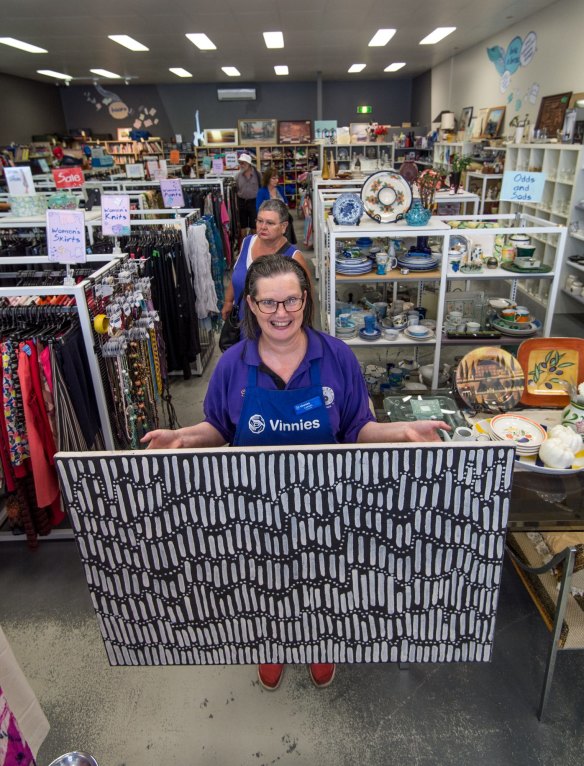 Carmel Miller from the Sydney Road Vinnnies holds up 'Spearhead Dreaming'. 