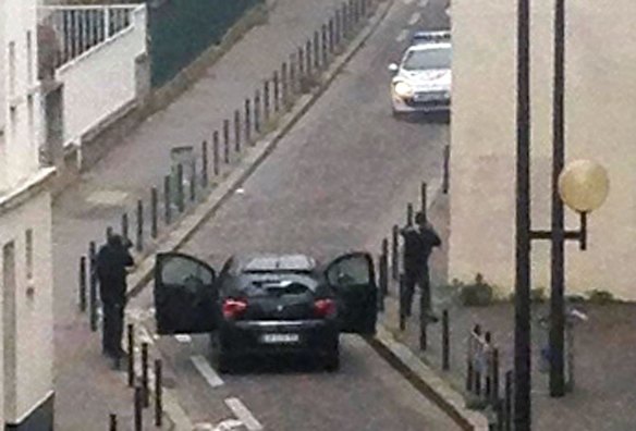 Gunmen aim their weapons at police near the Charlie Hebdo offices.