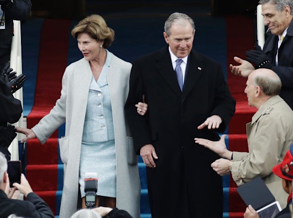 Former President George W. Bush and his wife Laura arrive for the 58th Presidential Inauguration at the U.S. Capitol, curiously minus their plastic ponchos.