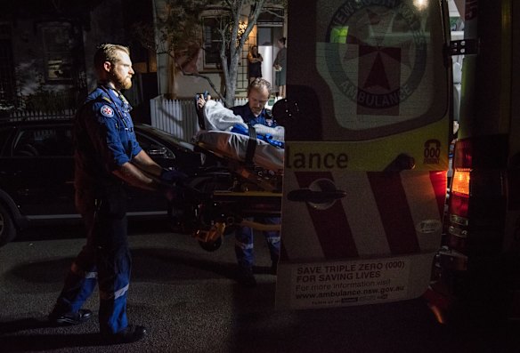 11:04pm. NSW Ambulance Paramedic Gareth Garne (left) loads a 70 year old male from Leichhardt into an ambulance. He experienced loss of conciousness and low blood pressure. He was stabilised and transported to RPA Hospital.