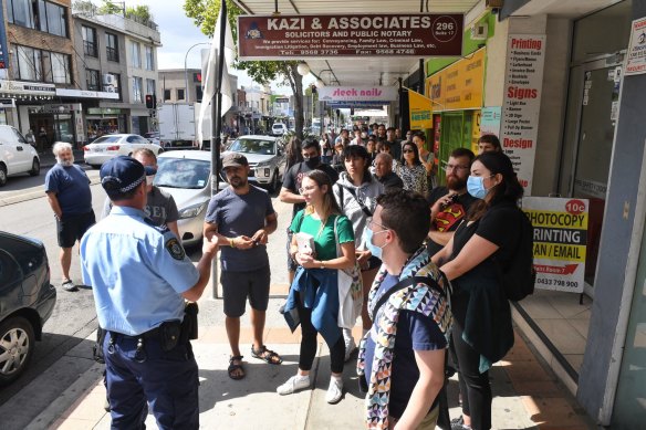 A police officer explains to people lining up at Marrickville's Centrelink that they will have a very long wait as Centrelink websites crash. March 23, 2020
