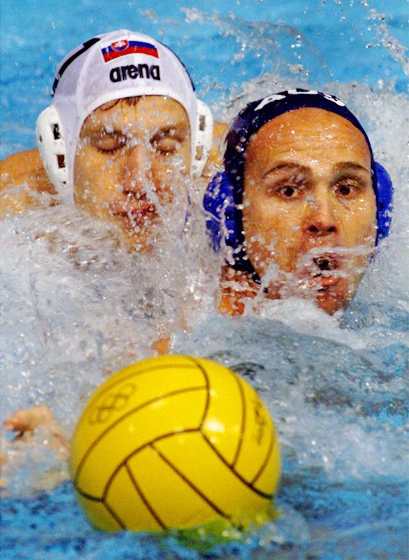 Australia's Nathan Thomas, blue cap, in action with Karol Baco from Slovakia during the men's water polo group A match.