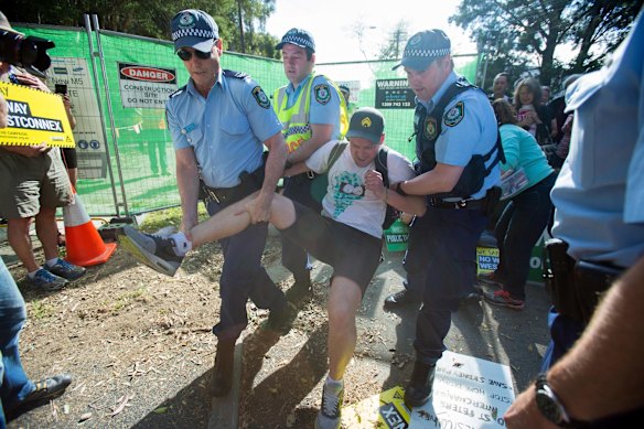 A protestor is physically picked up by police during a sit in protest.