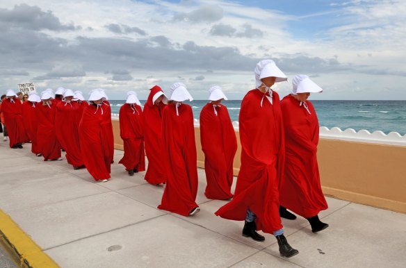 Protesters dressed as handmaids march in protest of Donald Trump near his Mar-a-Lago home on Florida's east coast on Saturday, January 20, 2018.