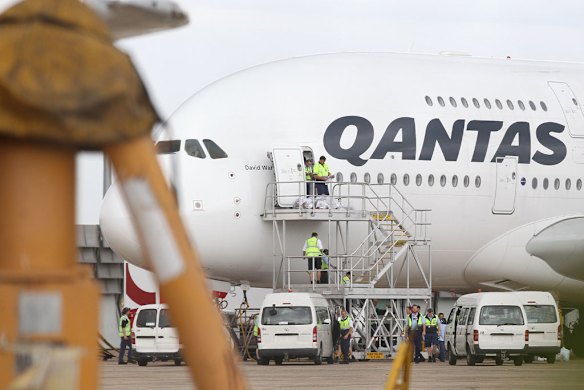 Qantas workers walk from an Airbus A380 jet at Sydney International Airport.
