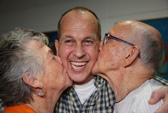 Peter Greste is kissed by his mother Lois and father Juris.