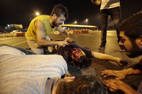 A heavily wounded man is attended to after clashes with Turkish military at the entrance to the Bosphorus bridge.