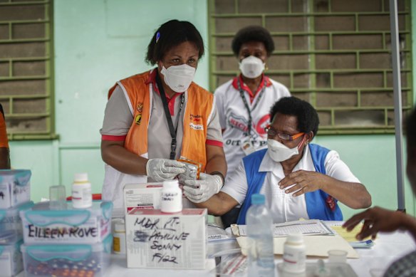 Medical staff handing out tuberculosis medication at the 6-mile health clinic. 