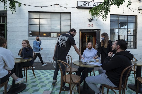 People are seen dining outside St. Ali Cafe in South Melbourne.