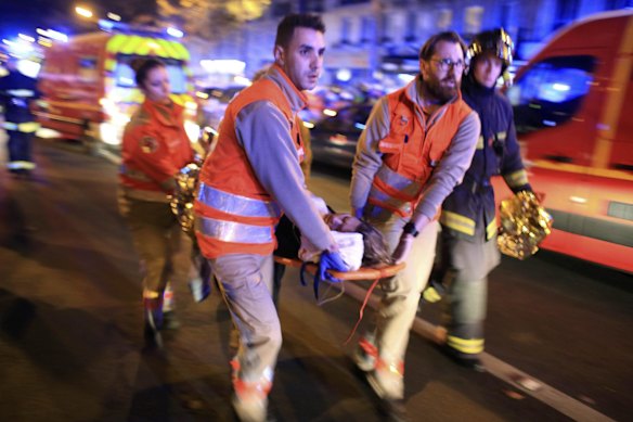 A woman is being evacuated from the Bataclan theater after a shooting in Paris.