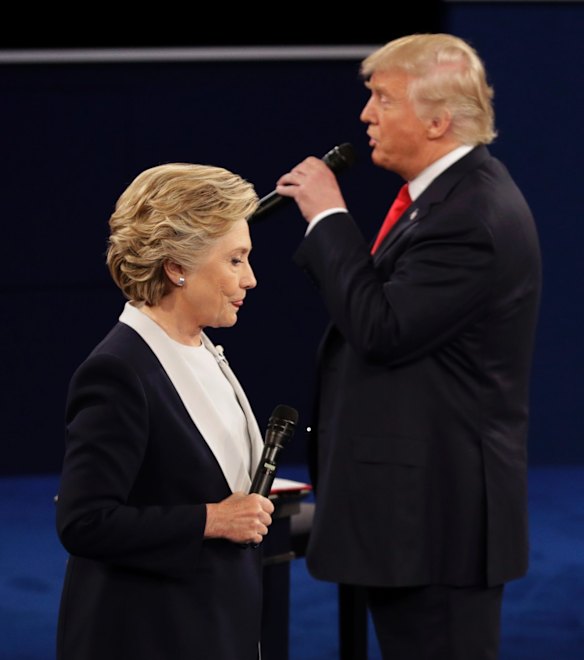 Democratic presidential nominee Hillary Clinton walks past Republican presidential nominee Donald Trump.