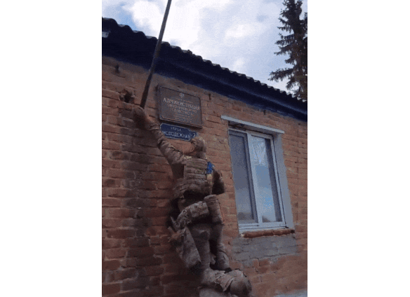 Ukrainian soldiers pull down a Russian flag. 