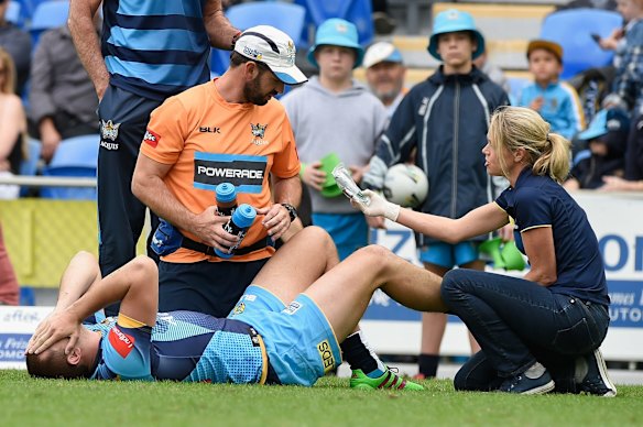 Nathan Davis of the Titans receives attention on the field.