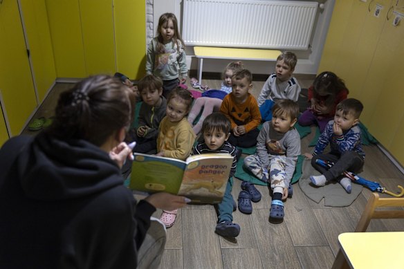 Julia Palovskaya reads to children during an air raid drill in the basement bomb shelter of the Smart English pre-school in Lviv.