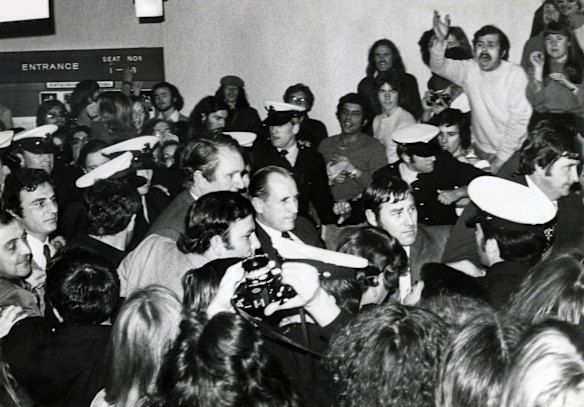 Malcolm Fraser surrounded by Police and bodyguards is pressed by the crowd as he attempts to leave the Alexander Theatre at Monash University. 25 August 1976