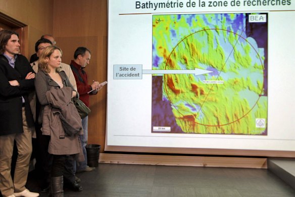 Jean-Baptiste Audousset (L), President of the AF447 victims association, and Gwenola (2nd L), whose fiance was among the victims of the crash of an Air France flight AF447, look at the research area map during a news conference at the French aviation investigation body BEA in Le Bourget, northern Paris.