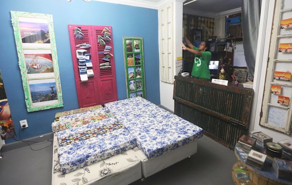 A worker stands at the reception desk of the Tiki Hostel in the Cantagalo favela.