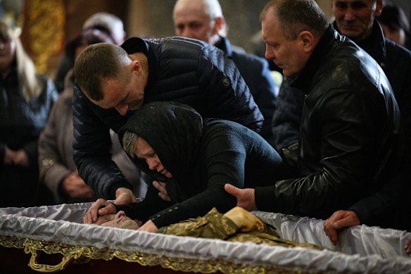 Family members mourn during the funeral service for fallen soldier Kobryn Oleg, 39, at Saints Peter and Peul Garrison Church in Lviv, Ukraine.