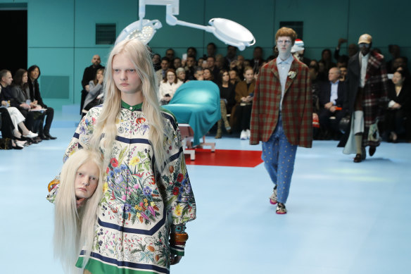 A model carries a fake head as she wears a creation as part of the Gucci women's Fall/Winter 2018-2019 collection, presented during the Milan Fashion Week, in Milan, Italy, Wednesday, Feb. 21, 2018. 