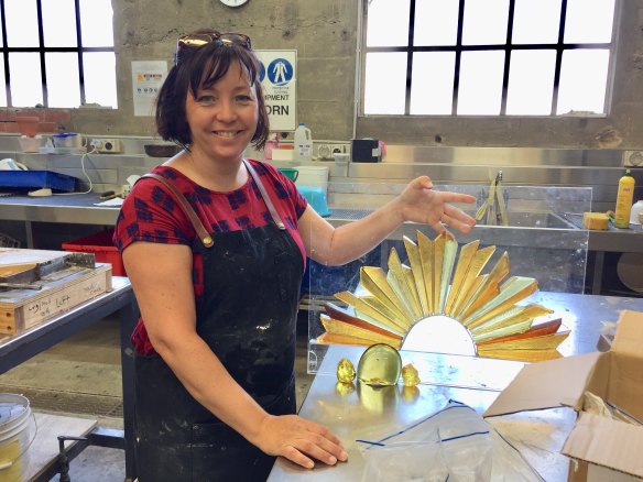 Canberra artist Lisa Cahill with a model of her Rising Sun sculpture which she made at the Canberra Glassworks.
