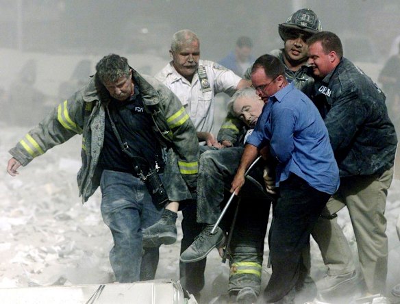 Rescue workers remove a man from the World Trade Center tower after in New York City September 11, 2001.