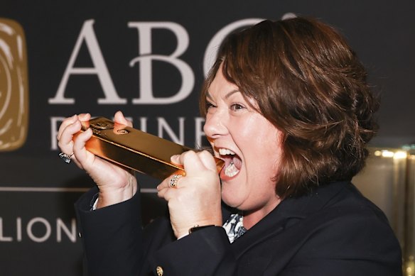 Labor MP Meryl Swanson pretends to bite into a 400 troy ounce gold bar during a Minerals Week showcase event at Parliament House on Thursday 3 June.