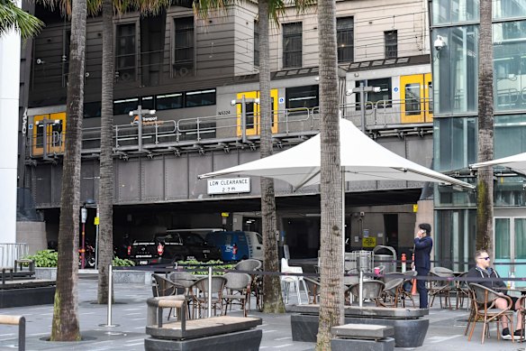 A train passes above a Circular Quay cafe area.