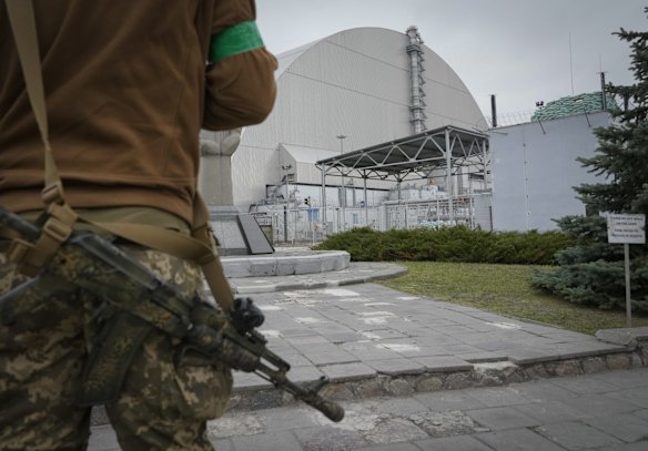 A Ukrainian soldier stands guard outside the sarcophagus covering the exploded reactor at the Chernobyl nuclear power plant.