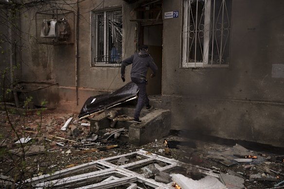A resident runs into his burning building after a Russian bombardment in Kharkiv.