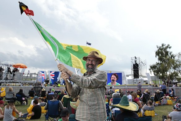 Ian Robertson of Morisset waves the Aboriginal and a Green and Gold flag.  