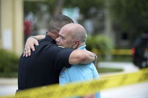 Terry DeCarlo, executive director of the LGBT Center of Central Florida, right, is comforted by an Orlando Police officer.