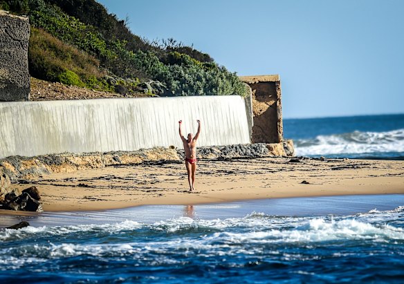 Grant celebrates on the beach at Point Nepean after successfully completing the swim. Photo: Justin McManus